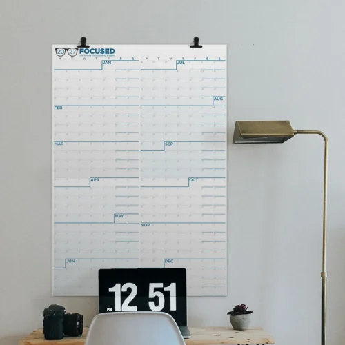 The 2027 Focused wall calendar hanging above a desk.